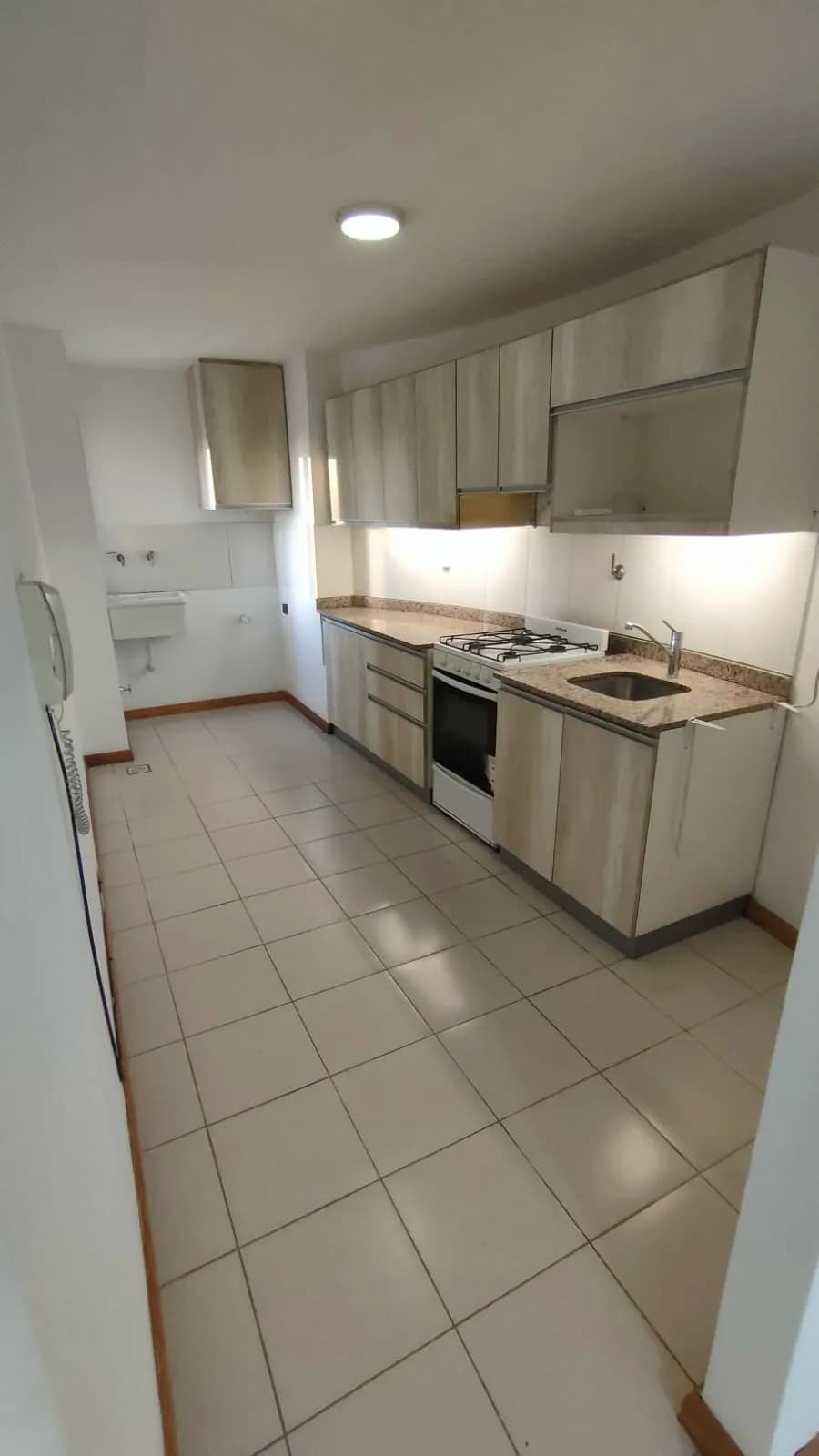 Cocina alargada con muebles claros