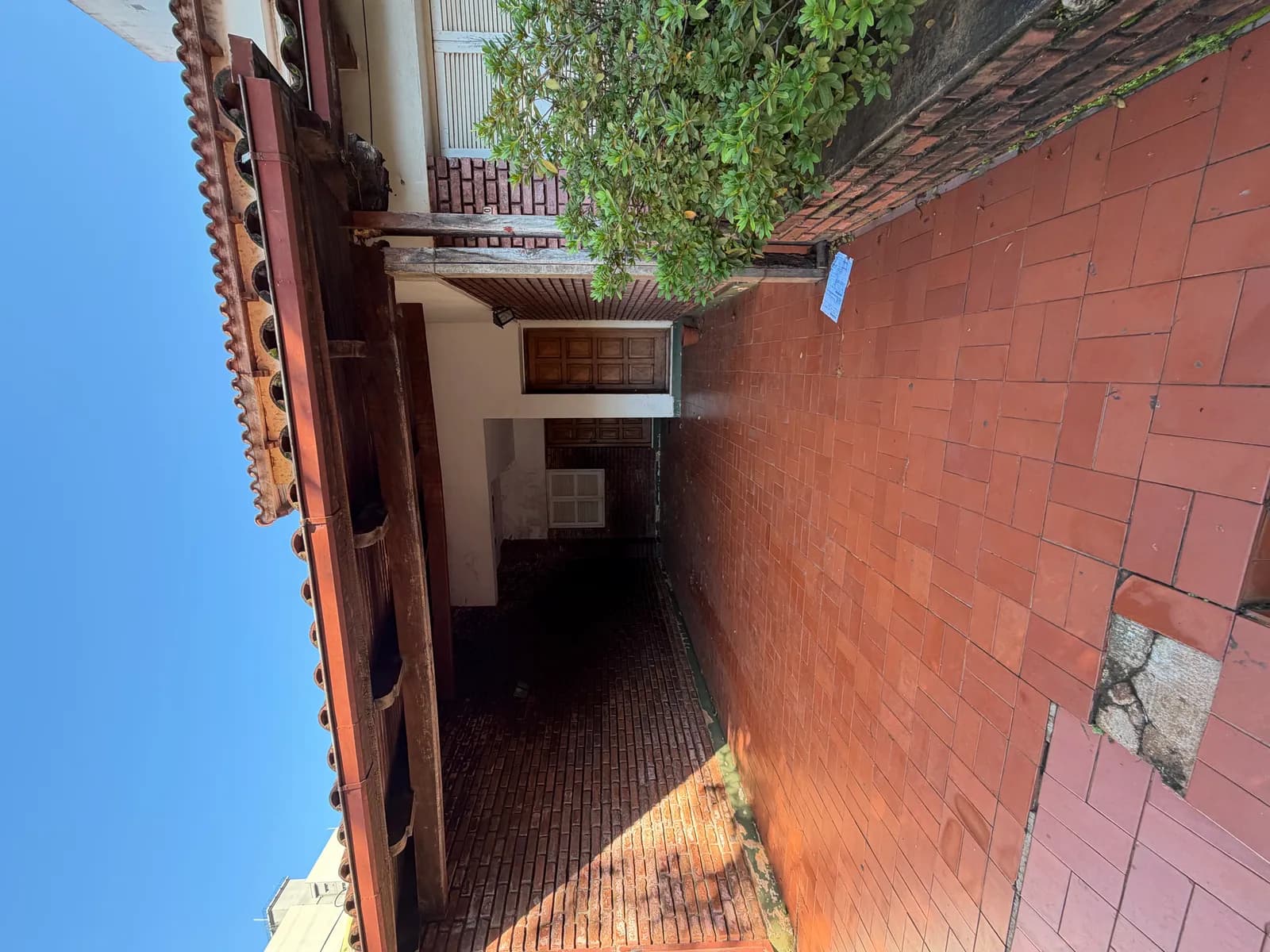 Pasillo exterior con baldosas rojas
