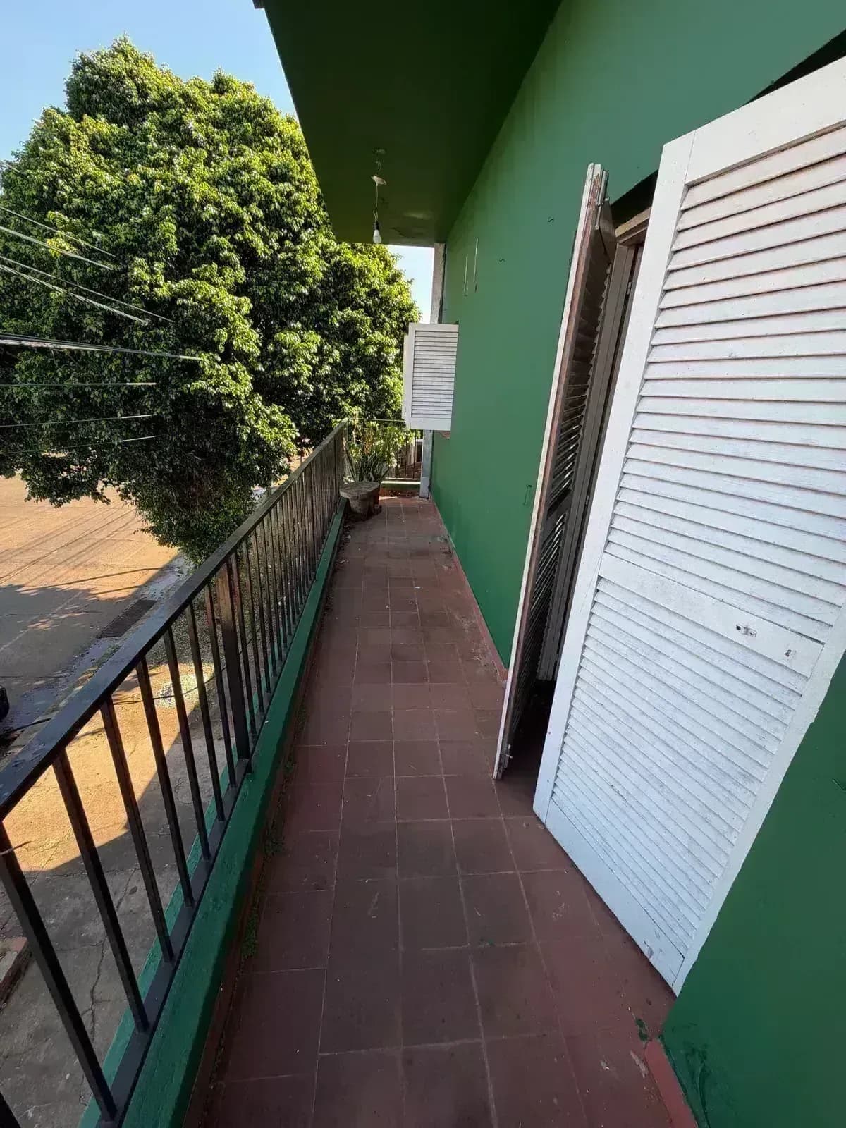 Balcón con baranda y paredes verdes