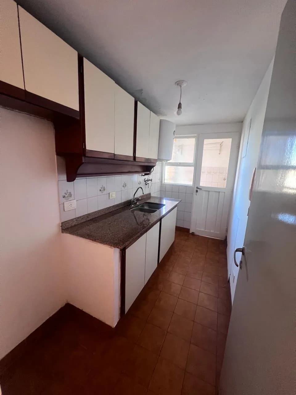 Cocina alargada con mesada de granito