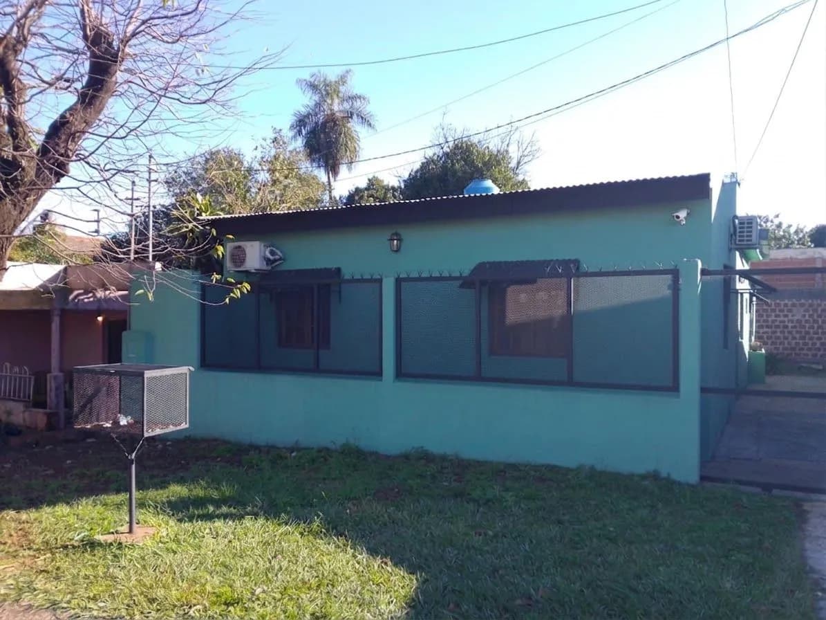 Casa verde con jardín delantero