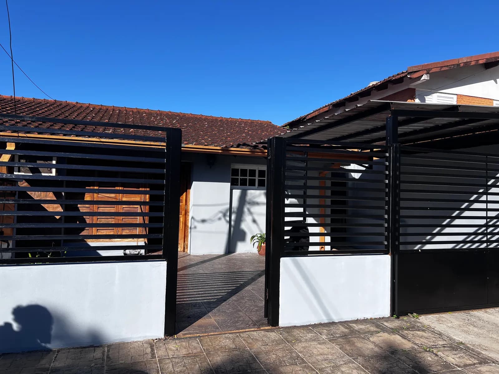 Fachada de casa con portón negro