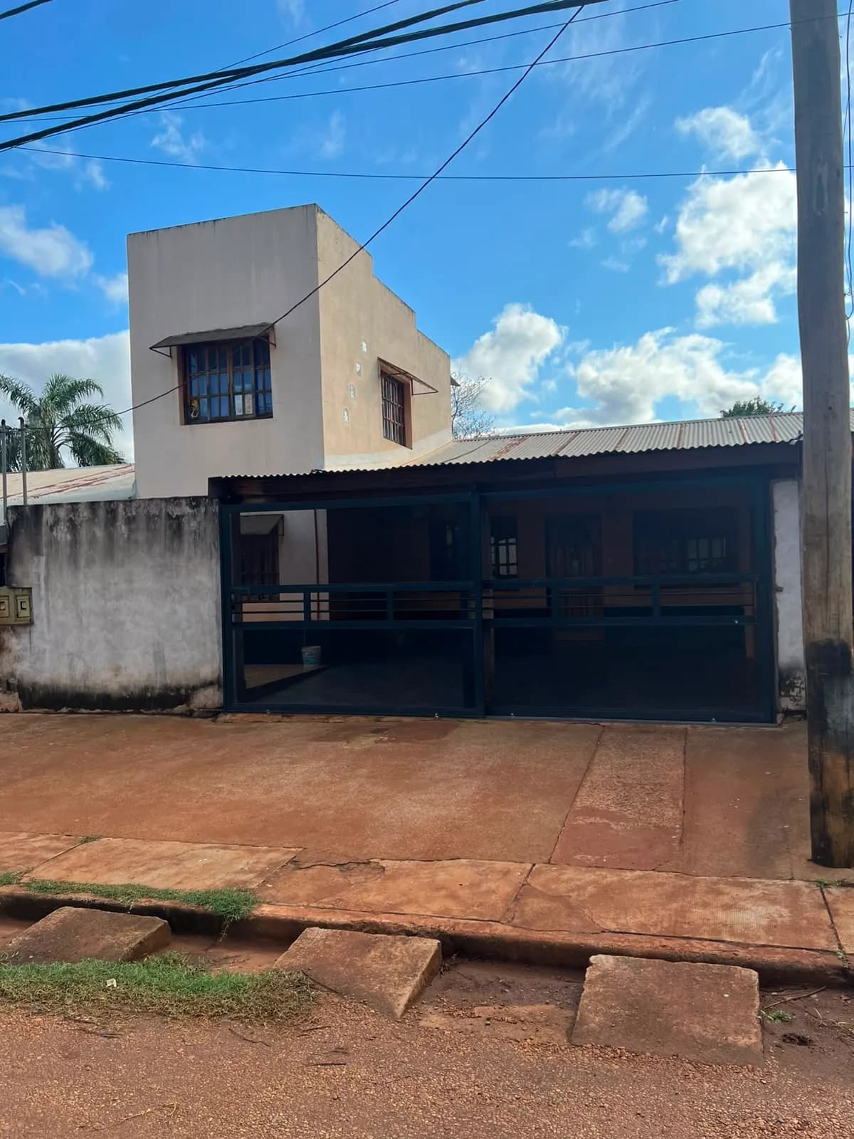 Casa de dos plantas con portón