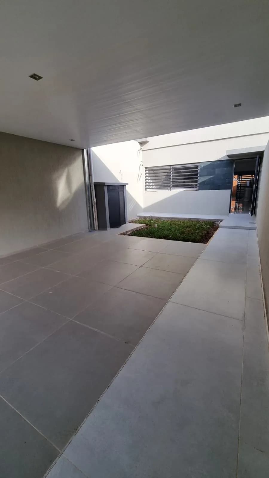Garaje techado con pequeño jardín