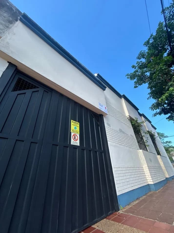 Fachada de casa con portón negro