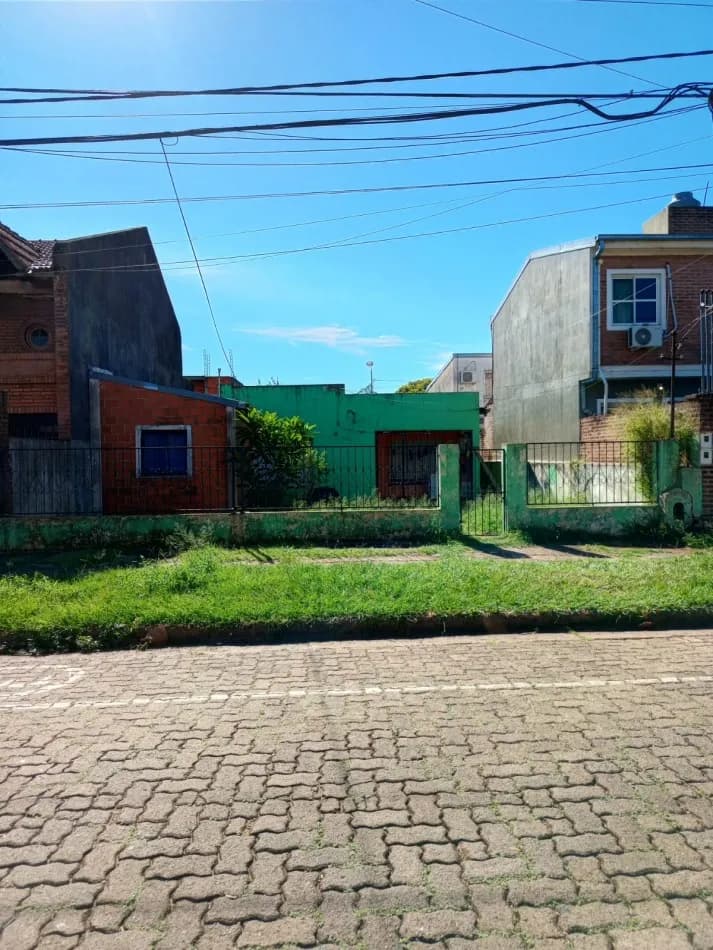 Casa verde sobre calle empedrada