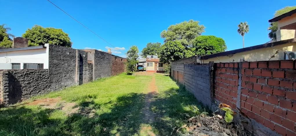 Terreno alargado con césped y muros