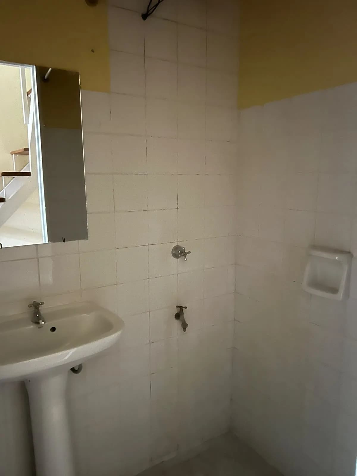Baño sencillo con azulejos blancos