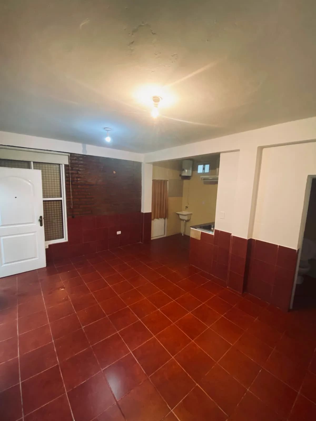 Espacio amplio con piso cerámico rojo